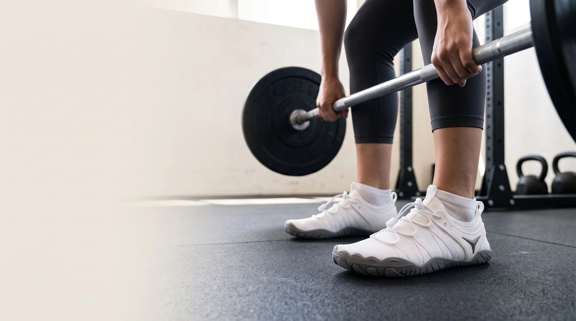 An athlete training in a gym in white Barevon cord-lace shoes